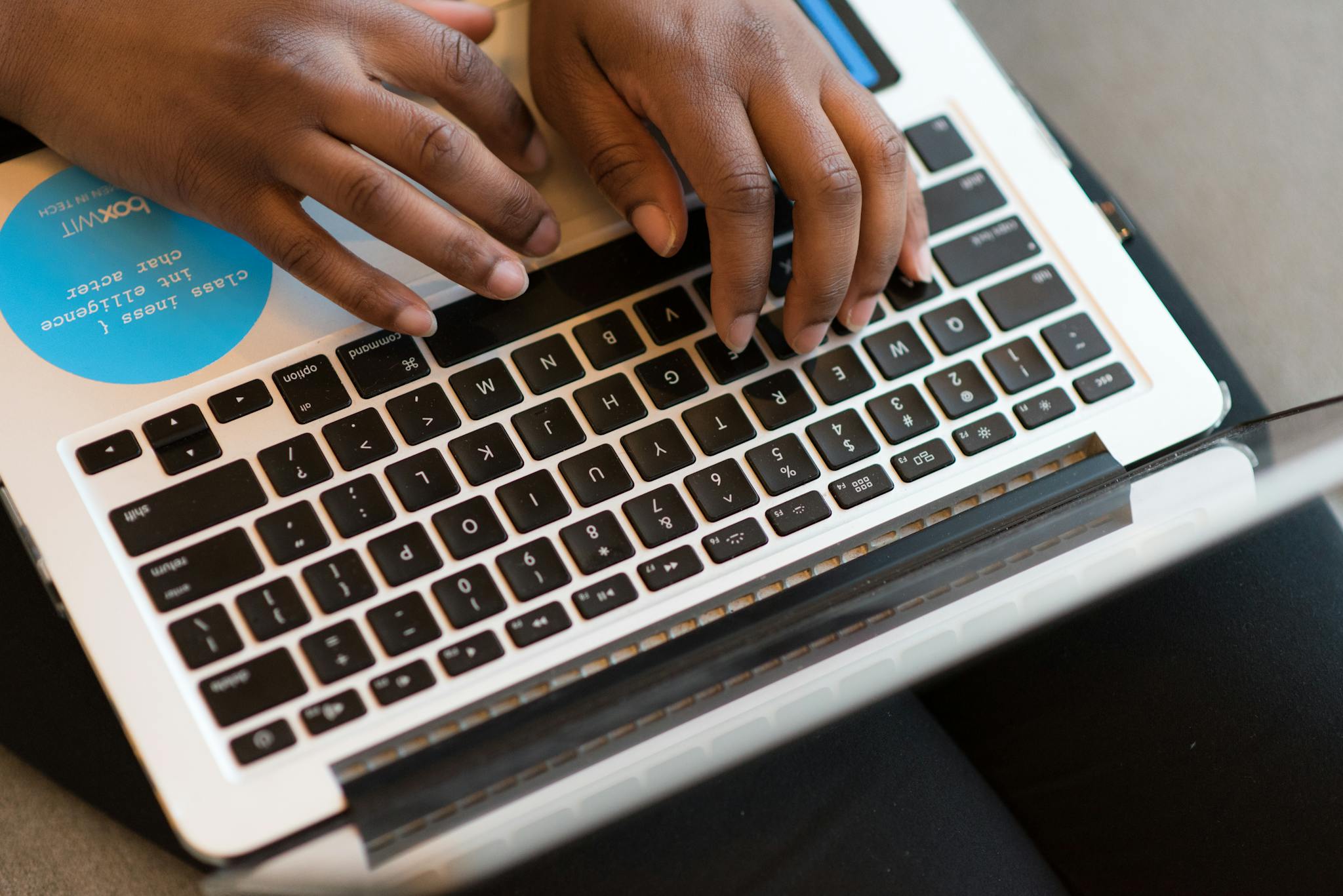 Close-up of hands typing on a laptop, showcasing modern technology and connectivity.